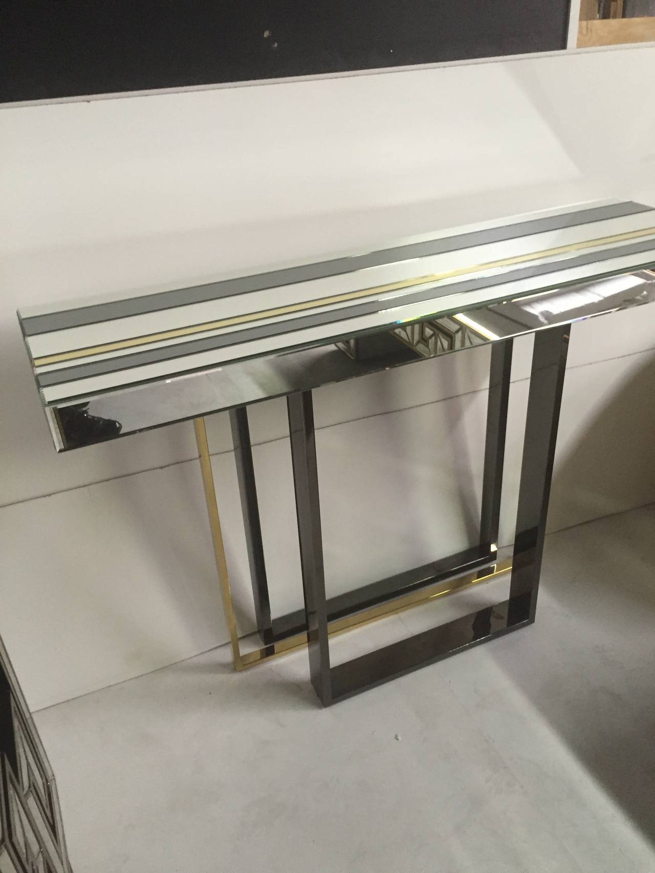 A two tone chrome and gold tone framed mirrored console designed in the manner of Milo Baughman's Stylish glass and tubular furniture.