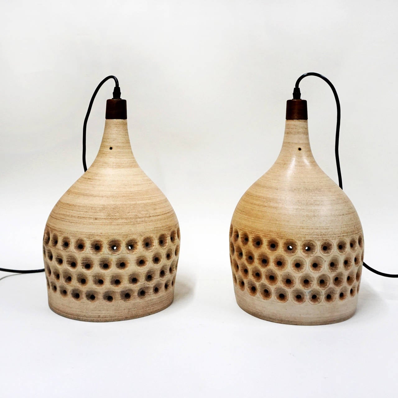 A pair of Design Technics ceramic pendant lamps with walnut fittings. The pierced body gives a wonderful glow. New wiring.