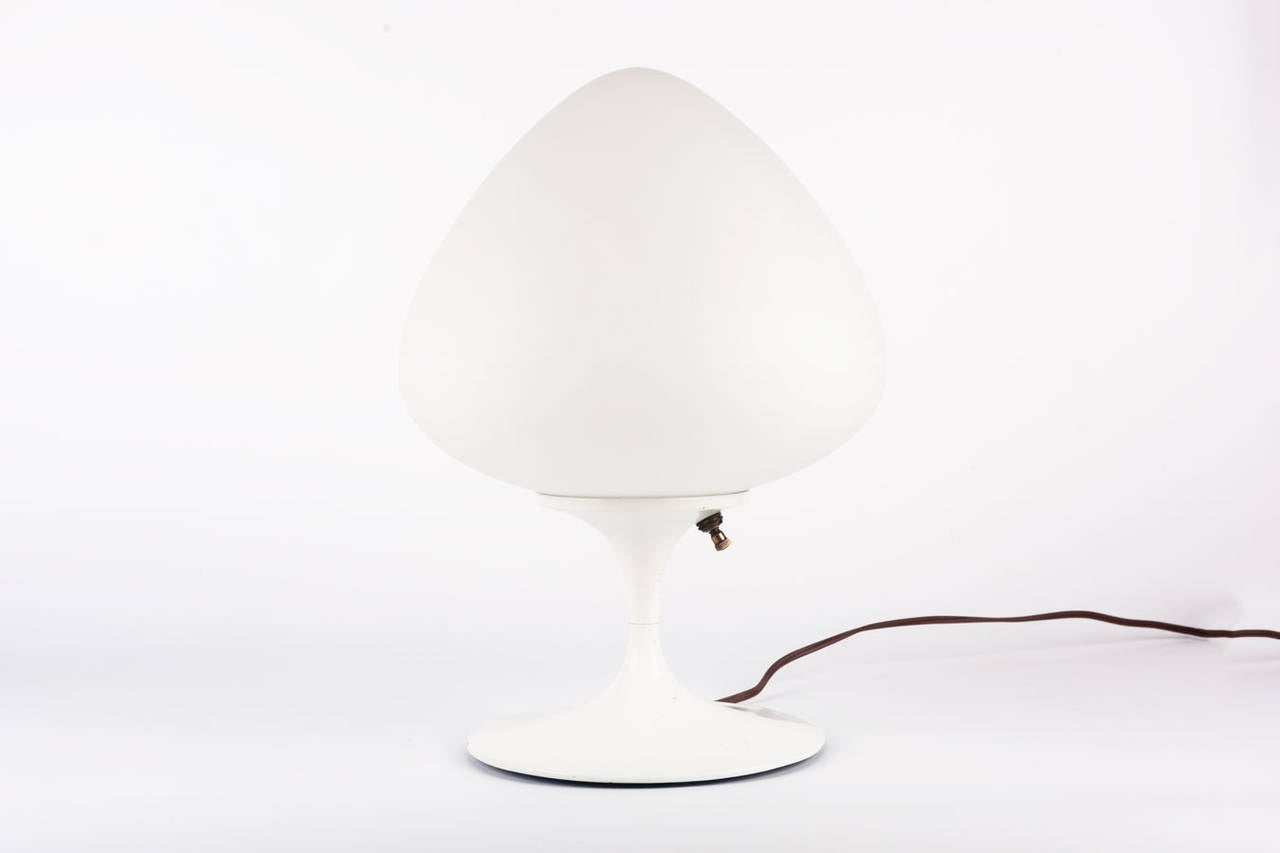 Laurel table lamp with a white metal tulip base and a flawless, acorn-shaped opaline shade that gives a generous, glowing light. Perfect small lamp for a cozy setting in a bedroom or meditation room. Elegant shapes and texture, the smooth surface of