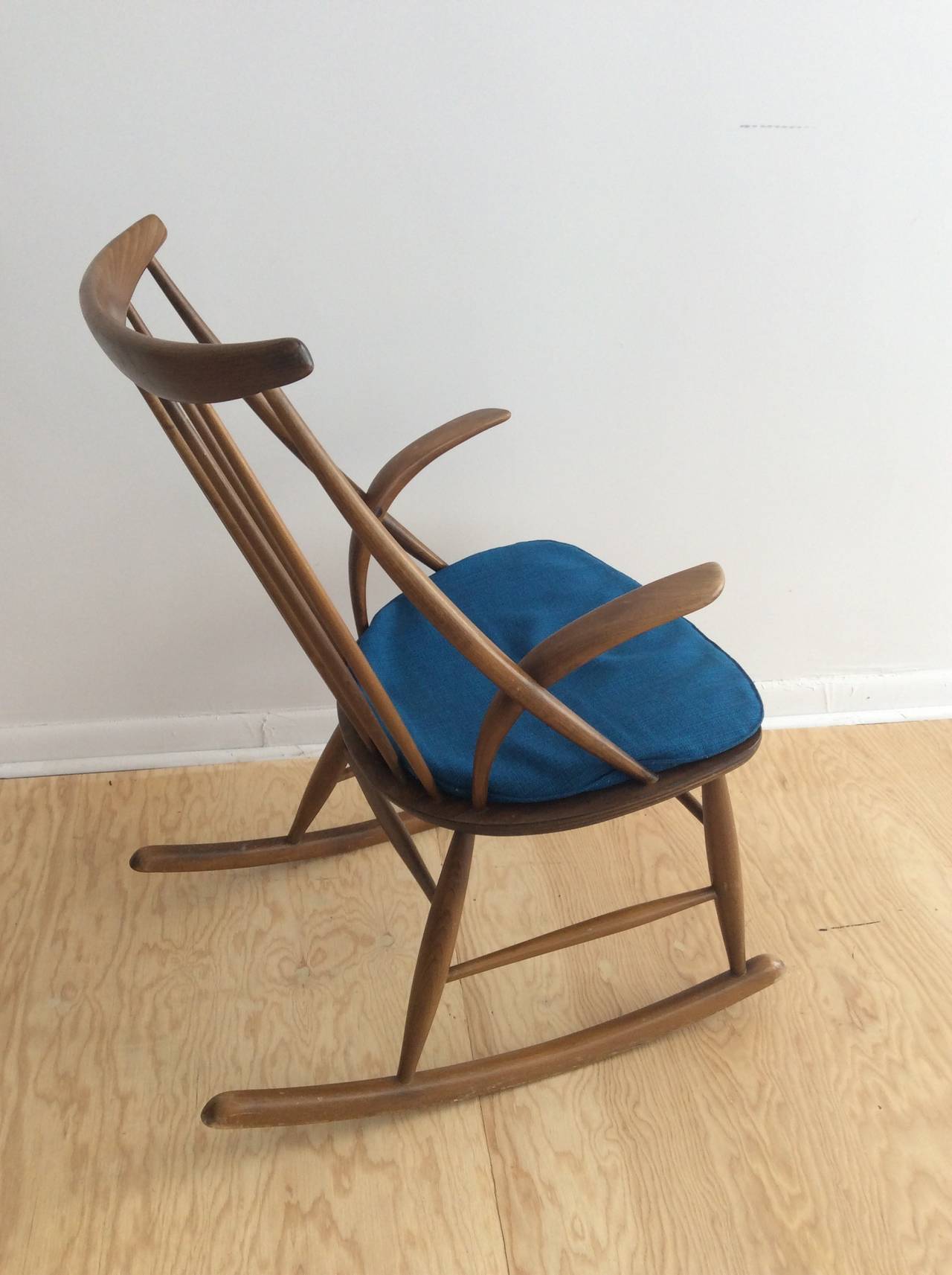 Danish rocking chair by Illum Wikkelso with blue cushion.