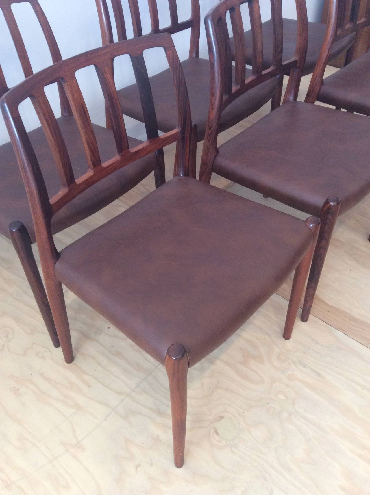 This is a beautiful set of model 83 rosewood chairs designed by N.O. Møller for 
J.L. Moller. Made in Denmak. Overall in great shape with original brown leather upholstery.