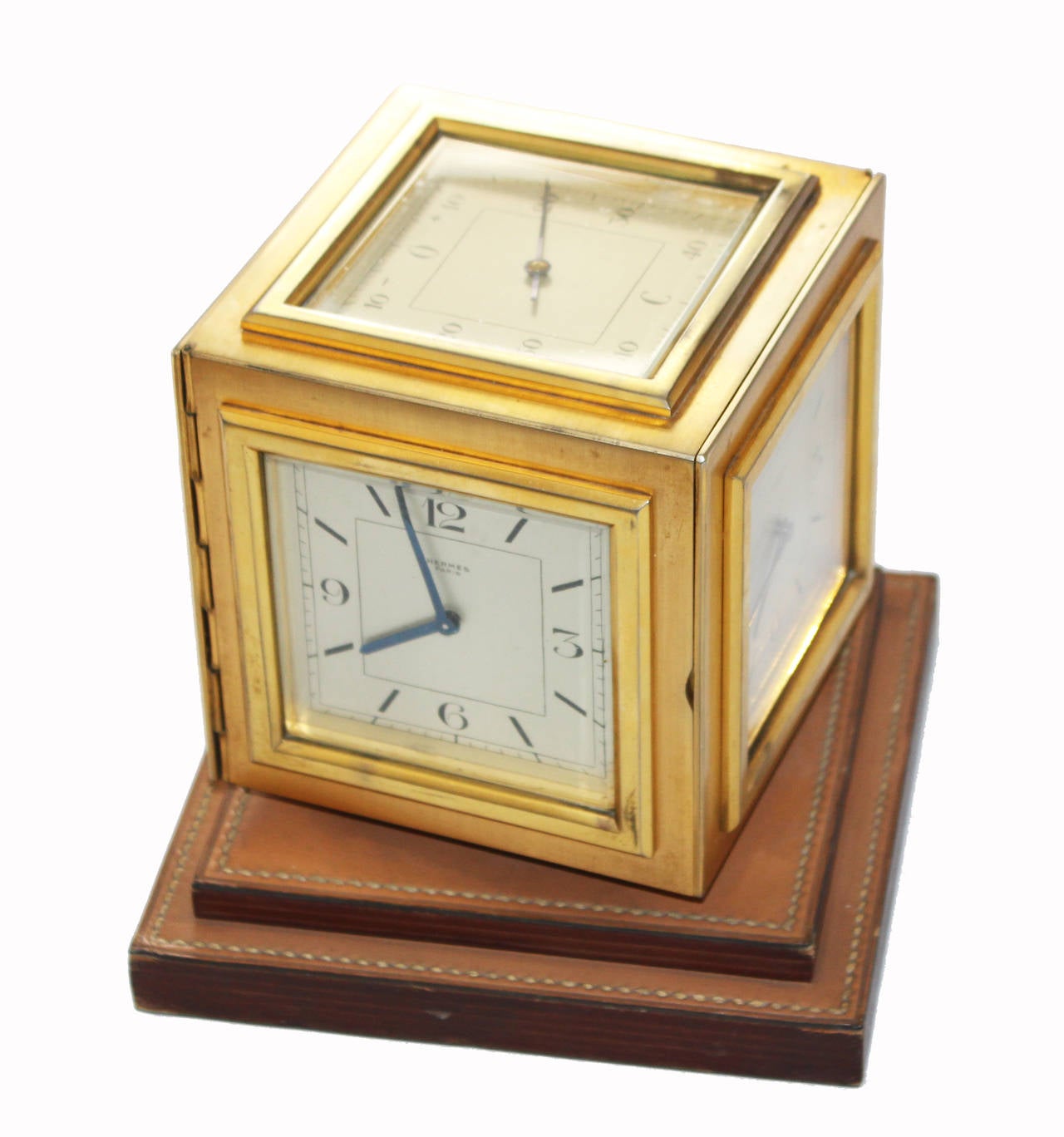 Exceptional Hermès Clock cubic desktop 5-sided golden brass, c. 1950. Thermometer on the window above. Mechanical movement. Two side access hatches in control of the mechanism. Base with stepped lamella superposed pitting cowhide. Sand color. Size: