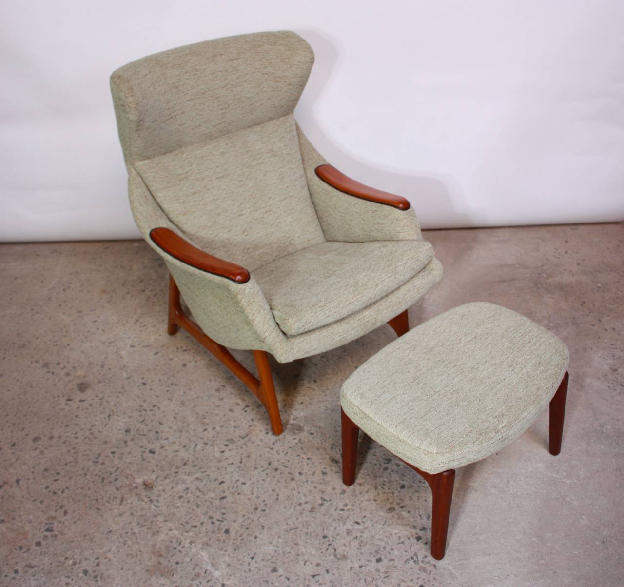 This sculptural lounge chair by B.J. Hansen of Norway has been newly upholstered in a mint chenille with leather detailing around the armrests. Both ottoman and chair are designed by B.J. Hansen of Norway, however the chair is constructed of solid