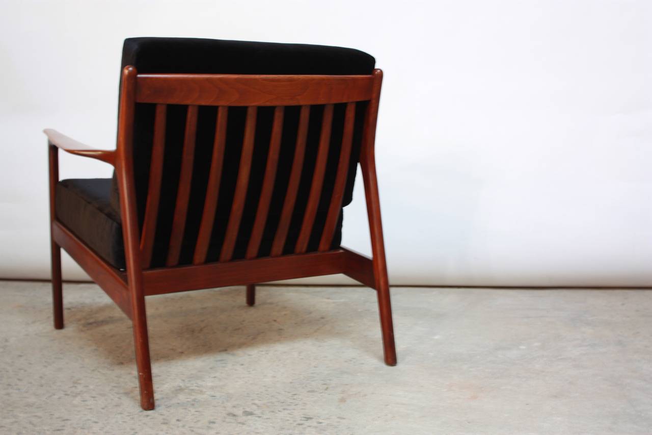 This Danish teak lounge chair is supported by a slat-back and rubber seat straps, which have been newly replaced. The black velvet upholstery is new, as is the foam.
The arm height is 21.5