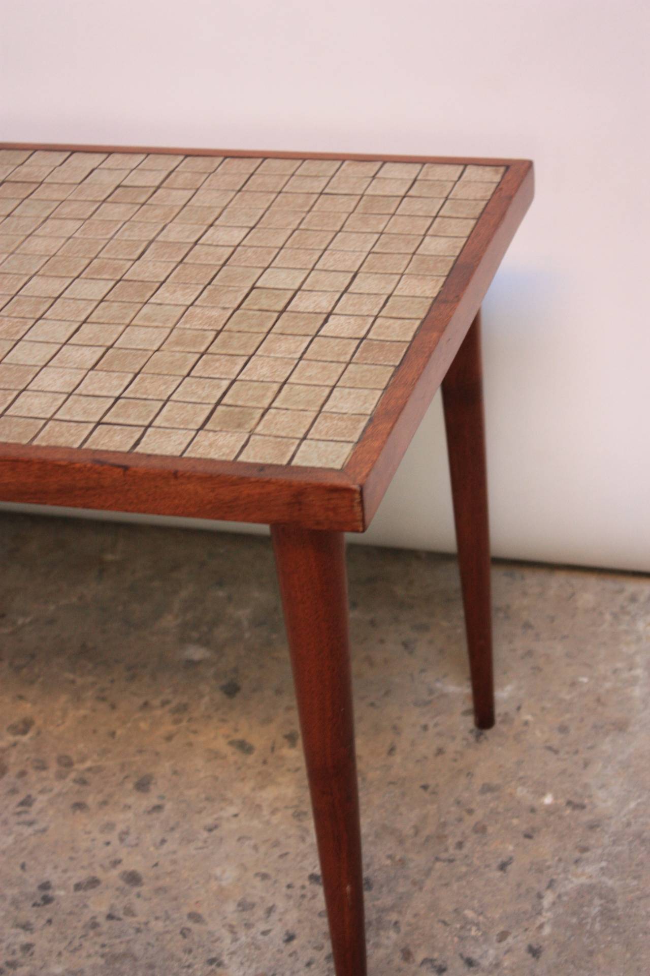 This tile-top table designed by Gordon Martz for Marshall Studios sits upon four removable walnut, tapered legs and is framed by a thin, walnut border. The piece is branded 'Marshal Studios' on the underside.