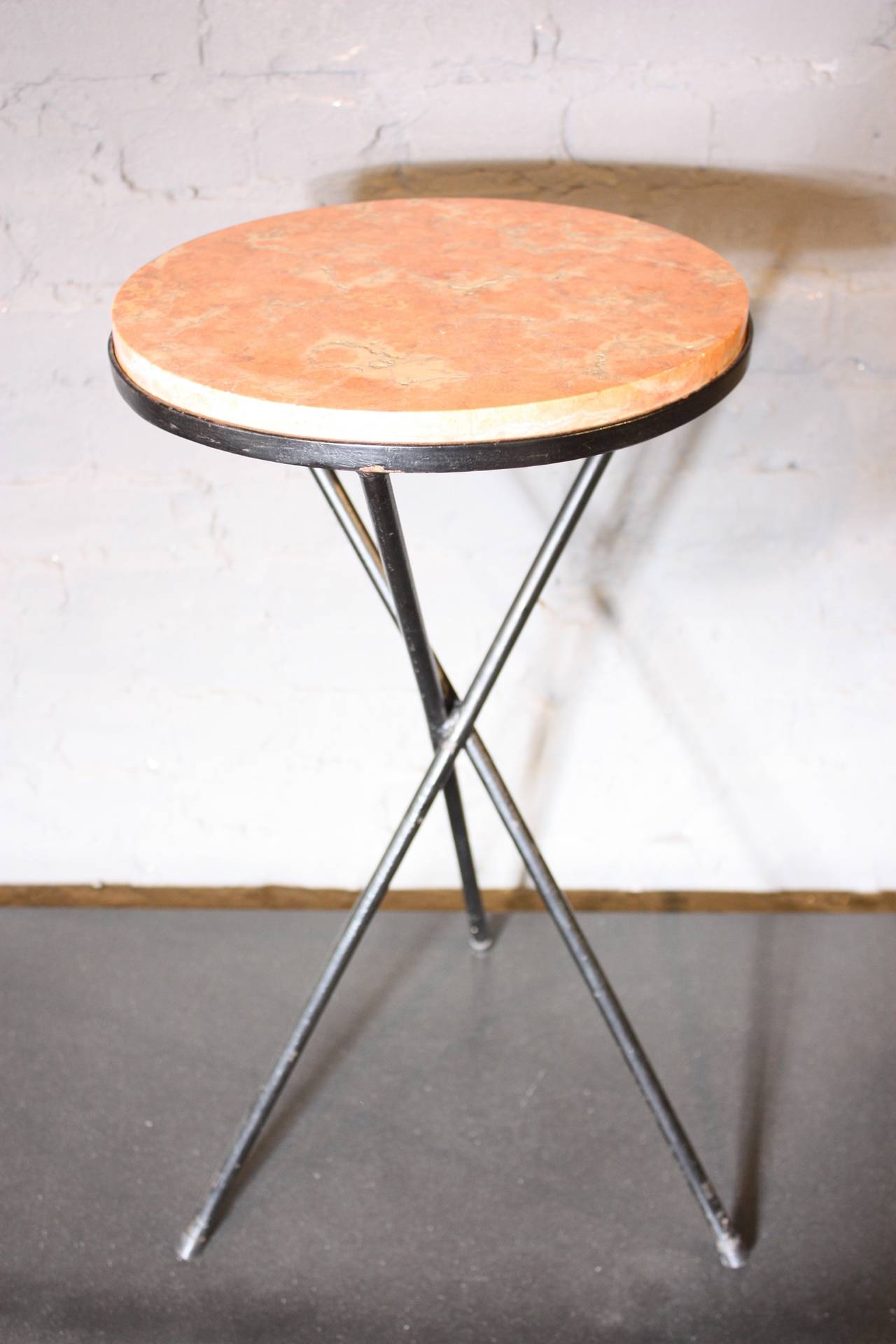 This 1950s French accent table features a wrought-iron tripod base which cradles a pink marble top. This is an elegant occasional table with clean lines.