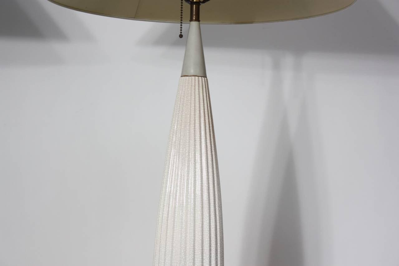 This elegant pair of Gerald Thurston table lamps features a crackle-bone white glaze body offset by walnut bases and colorful stems (grey with pale blue tones and black, respectively). The finials are original to the lamps and the shades are new.