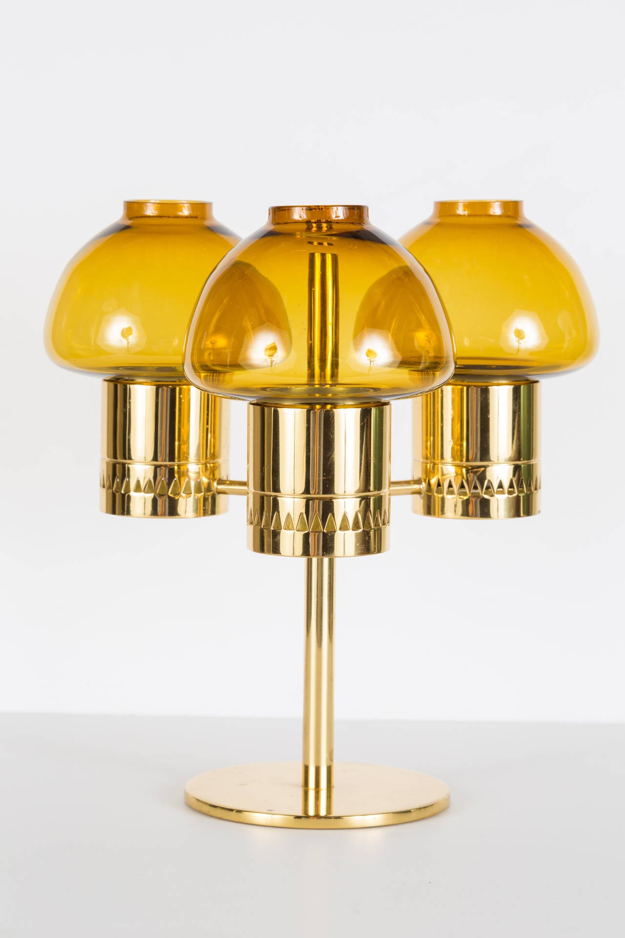 1960s Hans-Agne Jakobsson candelabrum for Markaryd. Amber glass and brass triple votive candelabrum. Elegant and refined design inspired by traditional Swedish oil lamps and Scandinavian Modern aesthetics.
 