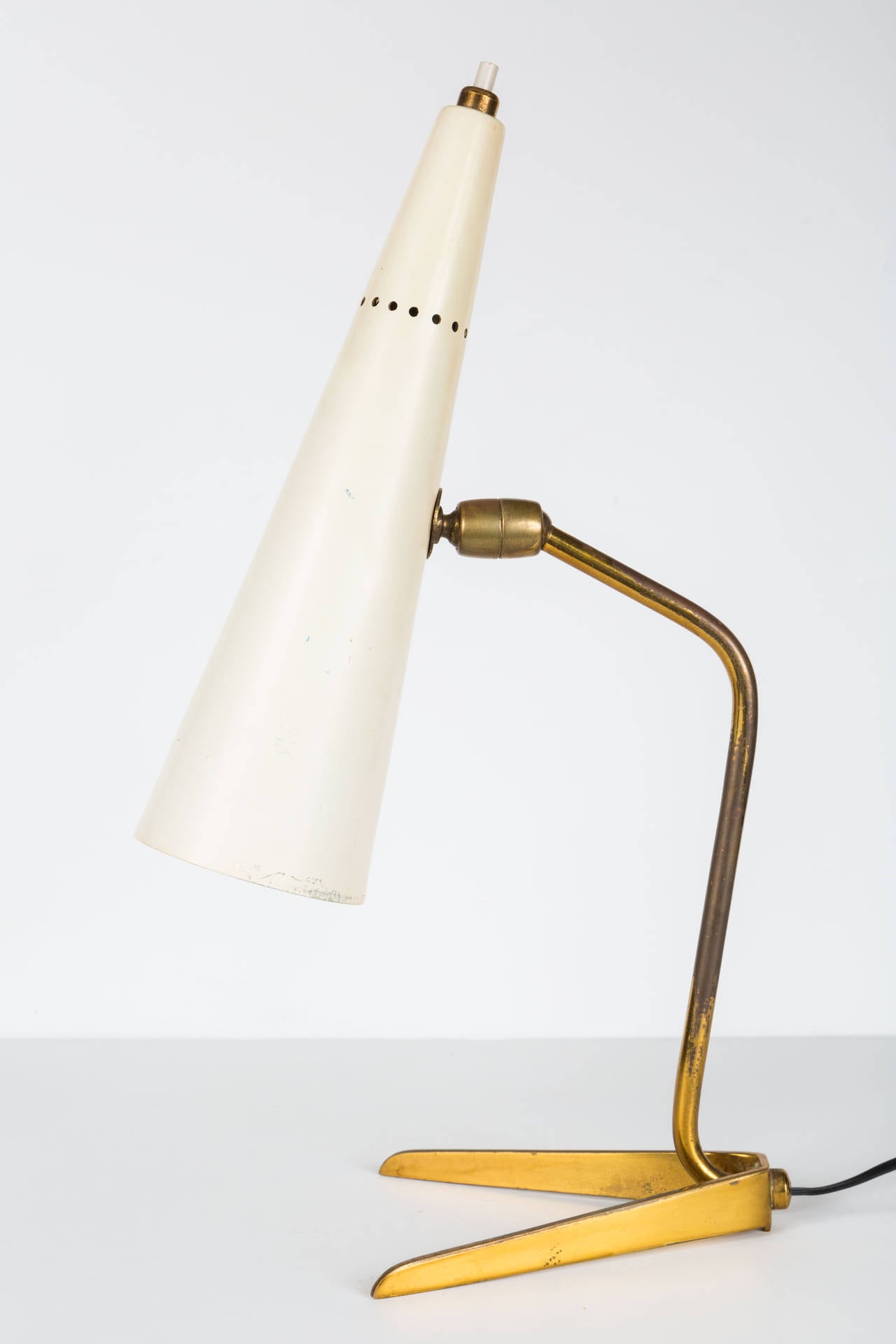 White cone adjustable table lamp with patinated brass arm and legs.