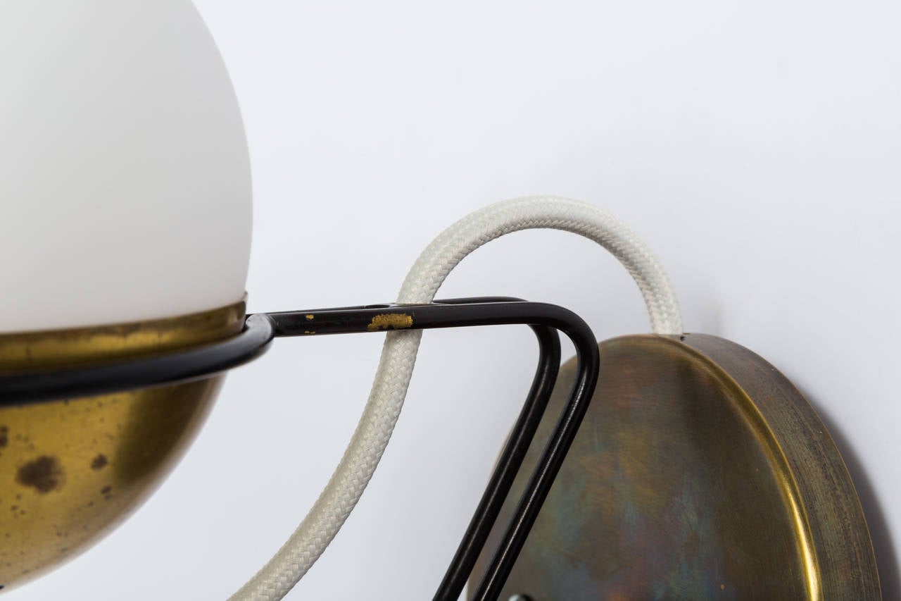 A lovely pair of sculptural Stilnovo sconces executed in brass, enameled metal, and matte glass.