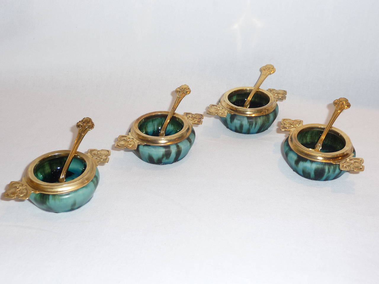 Eugene Baudin,
Alphonse Debain.
A set of six Art Nouveau salt cellars with four spoons; in its fitted box,
stoneware and vermeil.