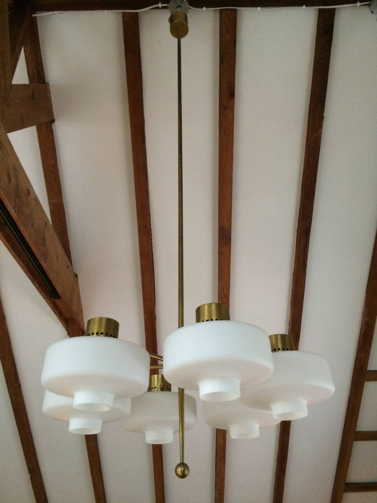Brass and opaque glass globed Swedish chandeliers taken out of a Swedish church undergoing renovation. The chandeliers are 8 feet in height but the brass center stem could be easily cut down to accommodate a shorter ceiling height.
We would require