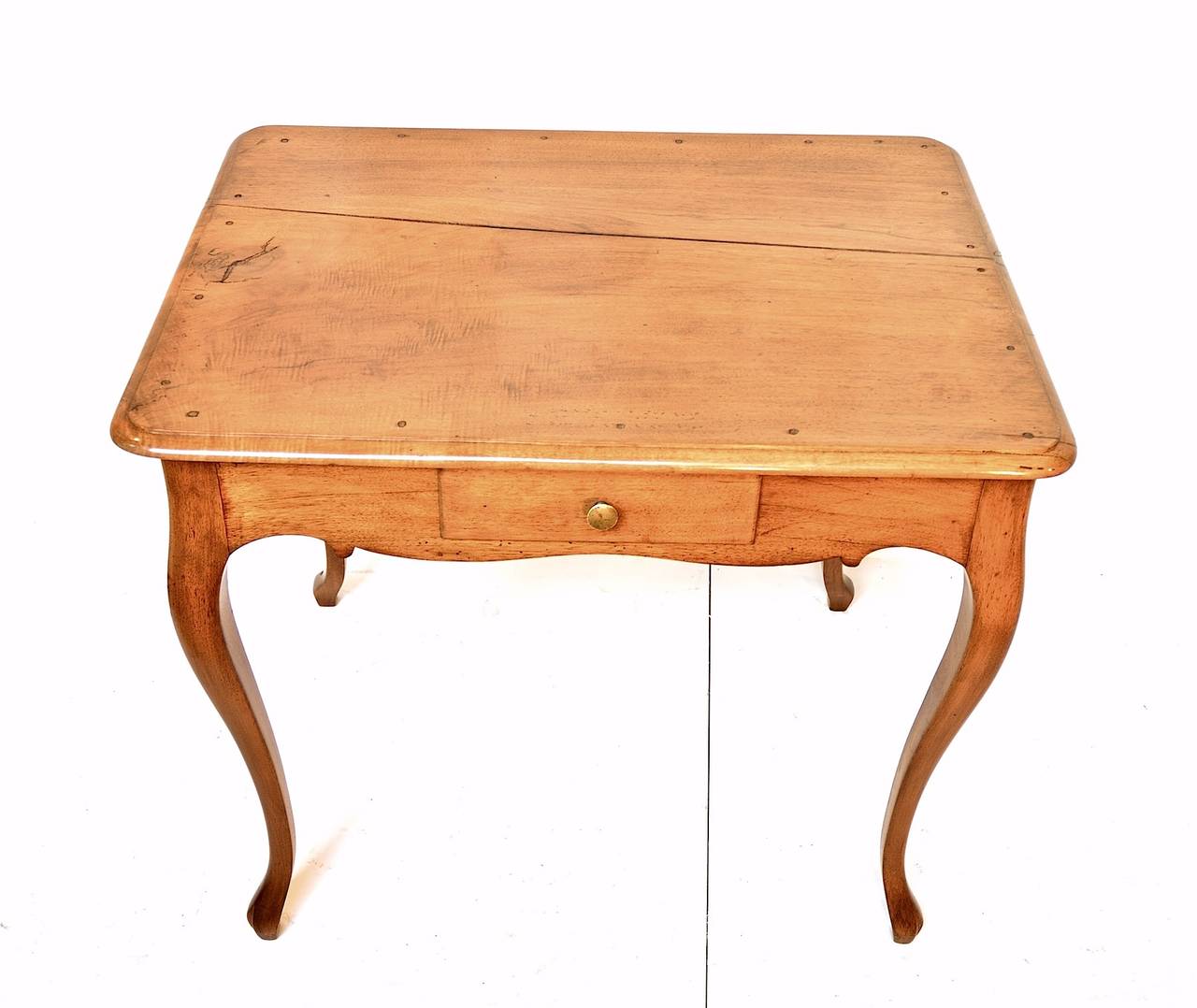 19th century Provincial occasional table of walnut having a single short drawer, pegged mortise and tenion construction and fabulous curvy legs terminating in simple hoof feet. The rustic and gently sun-bleached table is finished all the way around