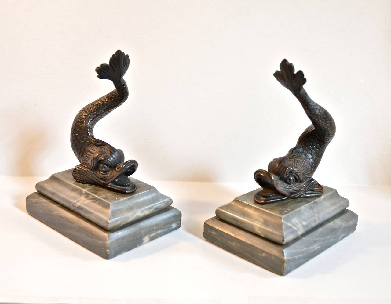 Pair of cast bronze dolphin bookends on gray marble bases. Early 20th. Century.  No maker's marks. Small chips on corners of bases.