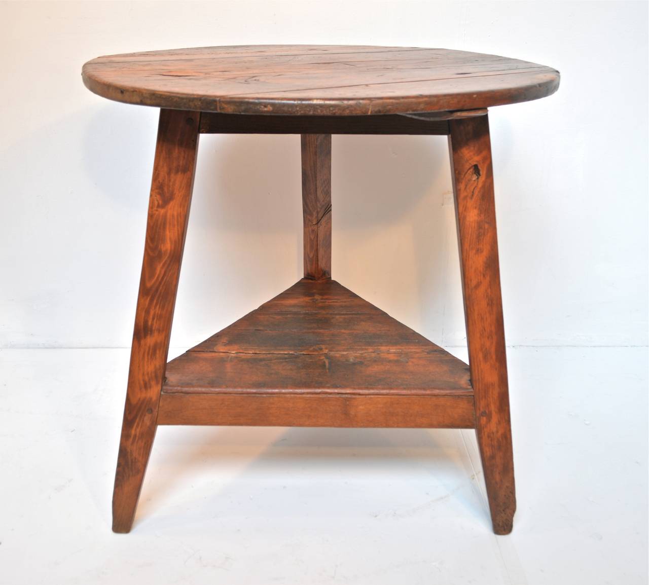 Late 19th century cricket table of pine and elm. The rustic yet chic lines of the useful table supply it with a great deal of versatility within any interior. Repairs to top and re-pegging of some joints along the way. 
Wear and age consistent with