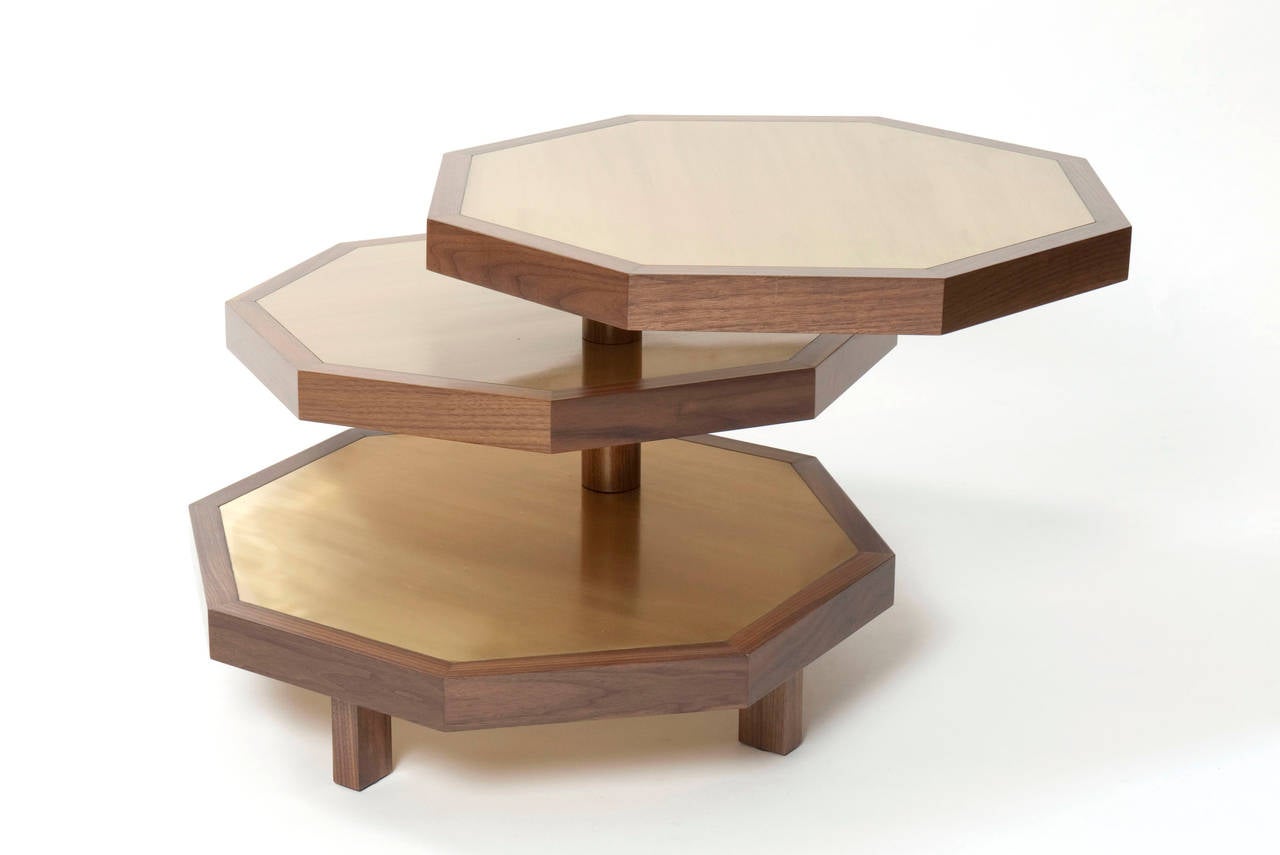 Octagonal walnut coffee table with three rotating tiers. Inlaid with brass veneers.
 
