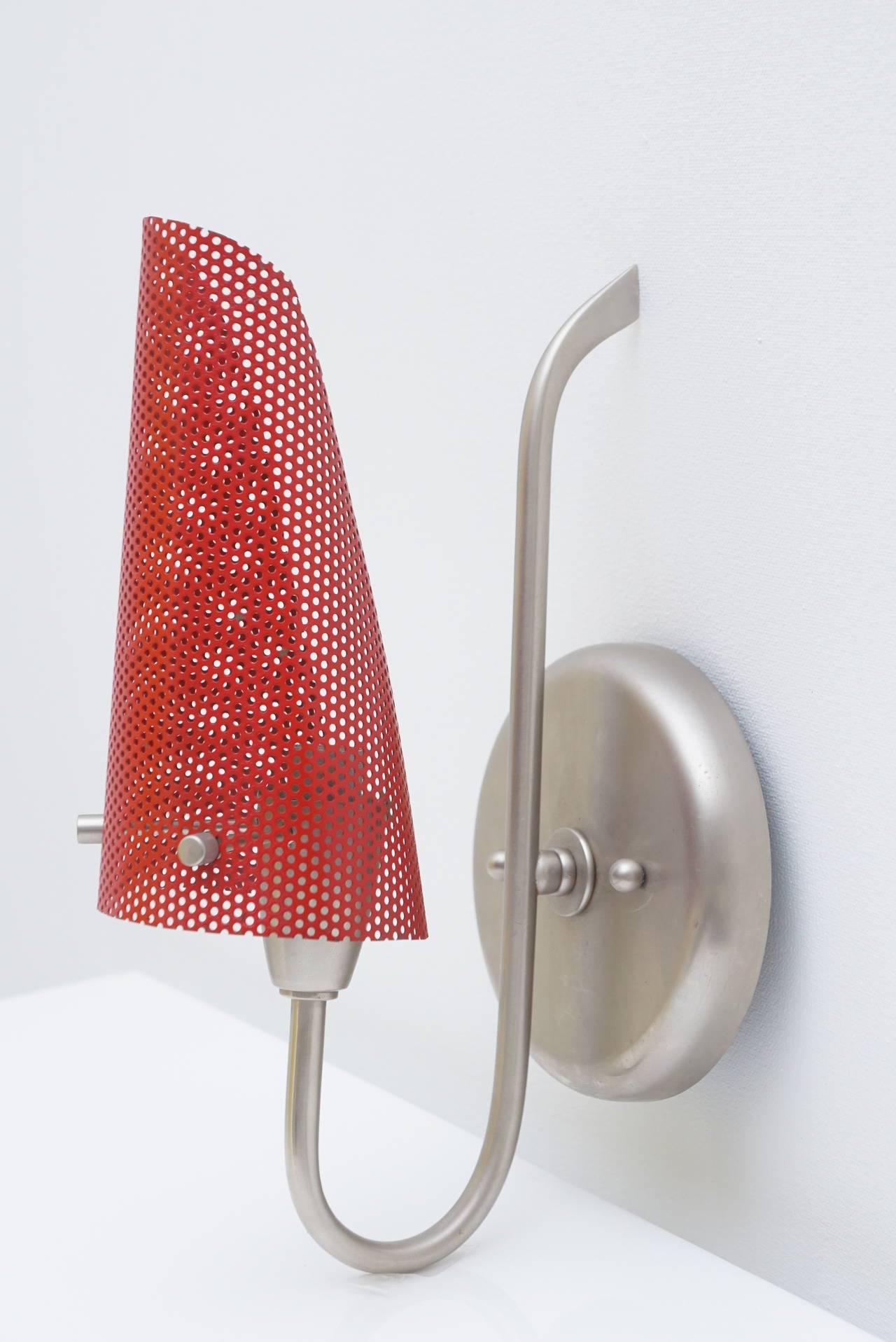 Vintage wall mounted sconce with perforated red painted metal shade. France, ca. 1950"s