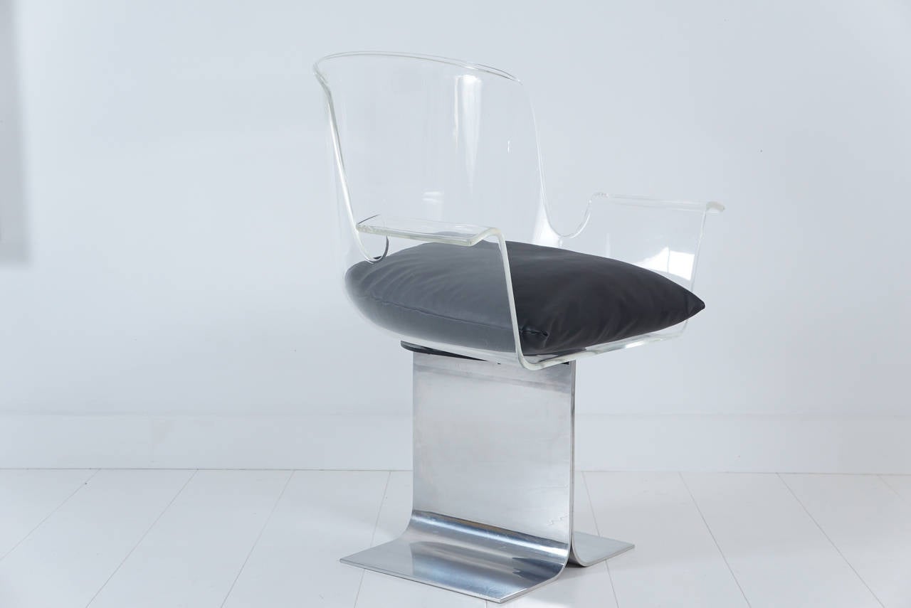 Lucite and polished aluminum swivel armchair in the style of Roger Tallon with pleather seat cushion.