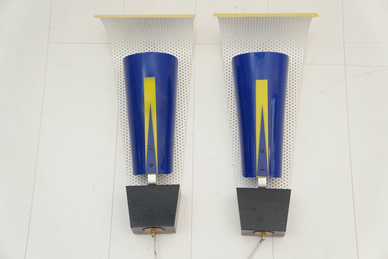 Pair, vintage wall sconces. White and yellow painted perforated metal back plate, blue and yellow acrylic cover mounted on black painted wood base. France, circa 1950s