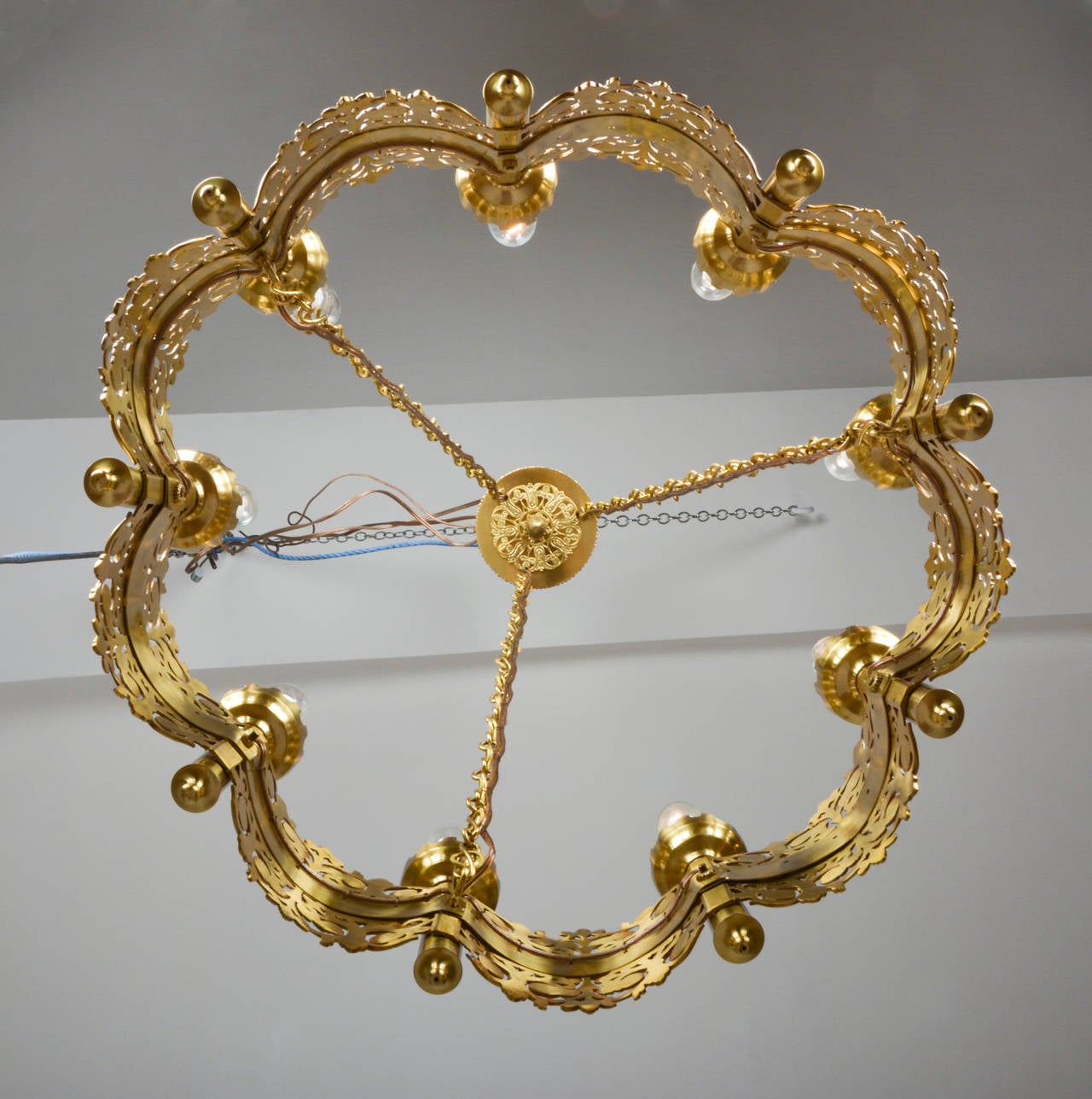 Brass cartwheel chandelier with refined cast applications.