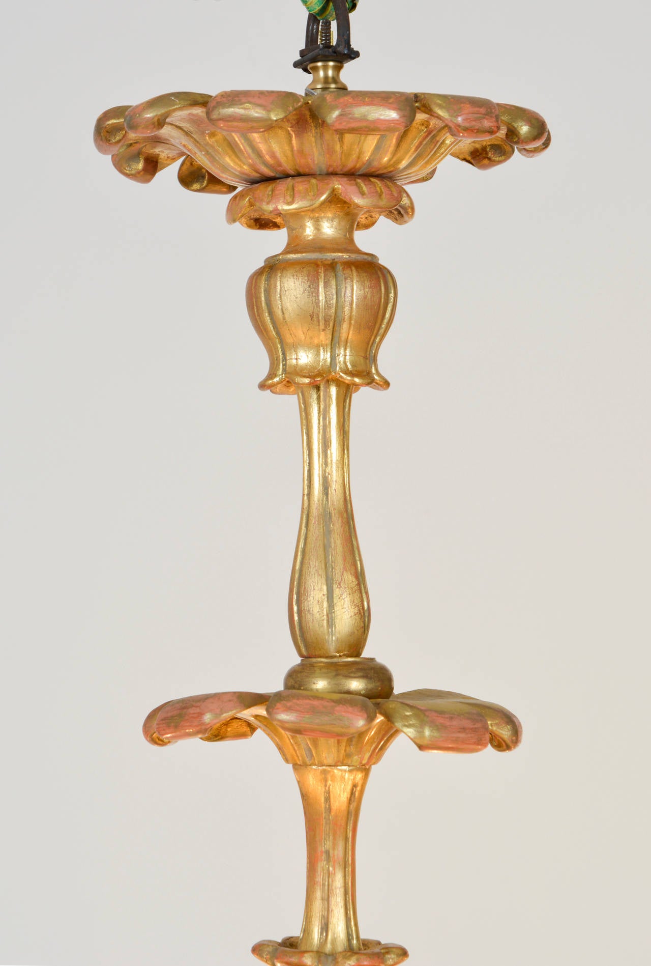 Twelve-light Baroque style chandelier made from expertly carved wood. Exquisite oil-gilded surface on chalk ground with partly polished areas as additional highlight. With exceptionally detailed column. Gold in color.
