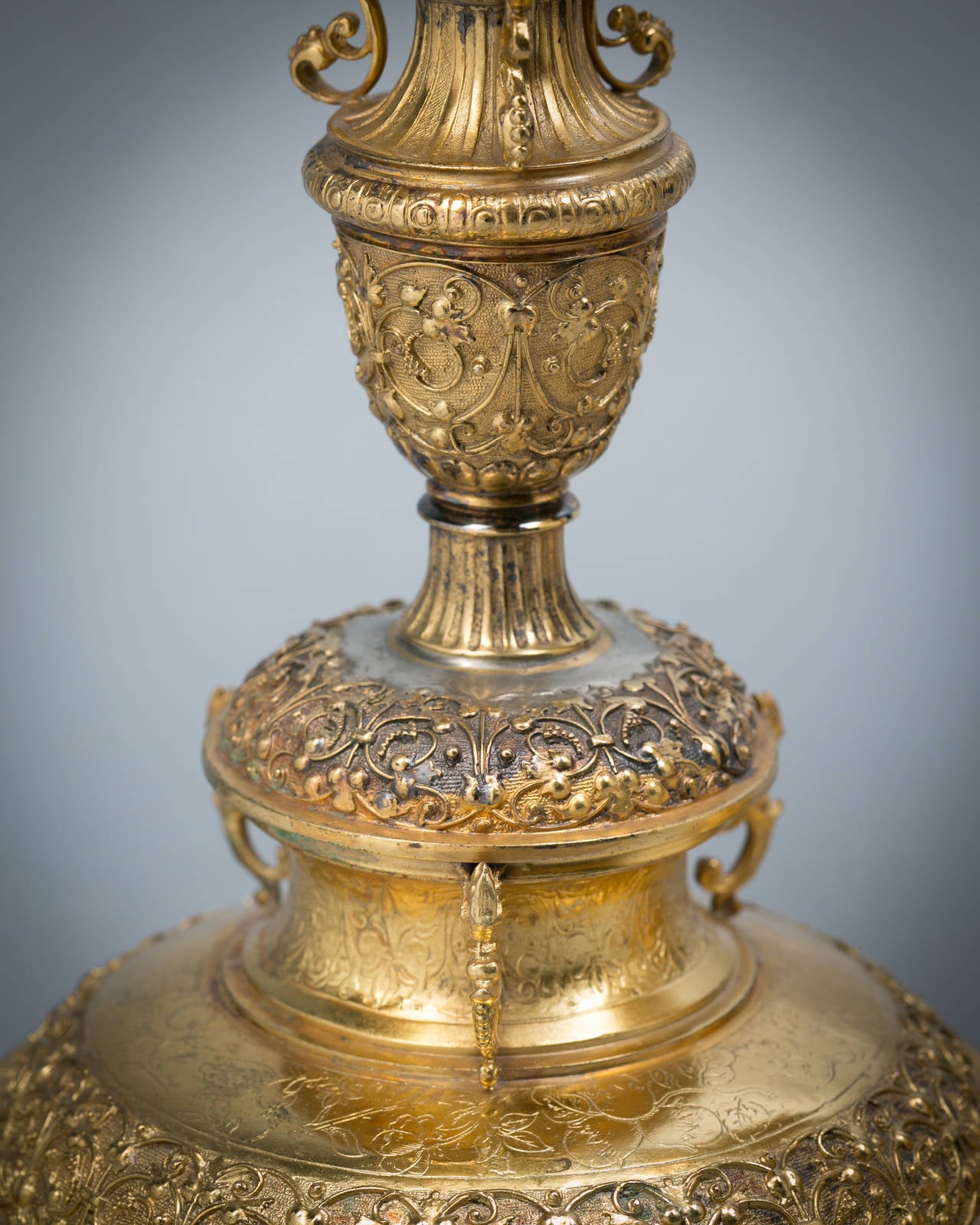 While apparently unmarked, this pair of standing cups are almost certainly by Elkington and Co. and are replicas of a silver gilt example in the Victoria and Albert Museum, hallmarked for 1611 with a makers mark of TYL. 
This standing cup at the V&A