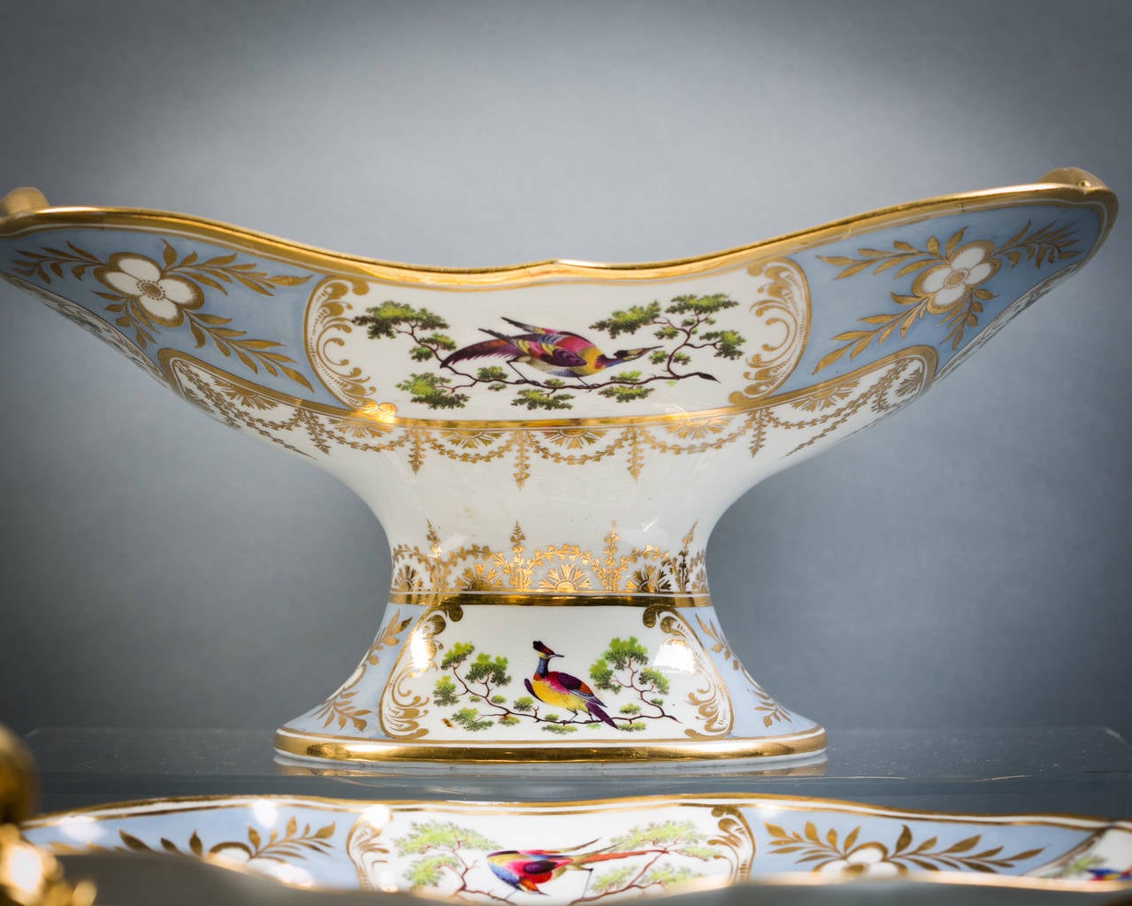 Comprising footed compote, pair of covered sauce tureens, one gallery (partially restored), pair of lozenge-shaped dishes, pair of kidney-shaped dishes, four shell dishes, four square dishes, 12 plates.