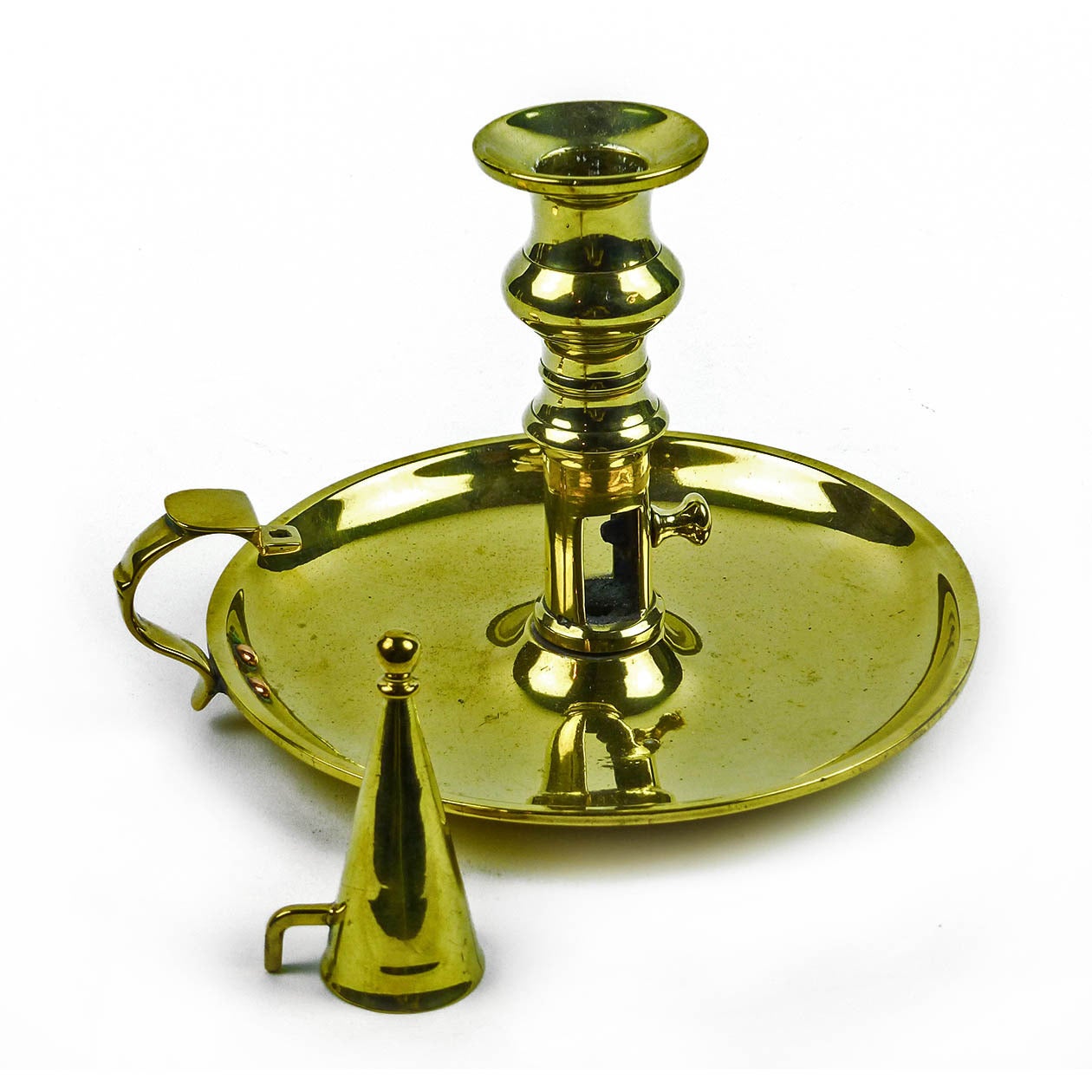 English brass side ejector chamberstick, circa 1800.

With snuffer. Cast shaft.

Measures: Height 4 5/8″, base diameter 6 1/2″.