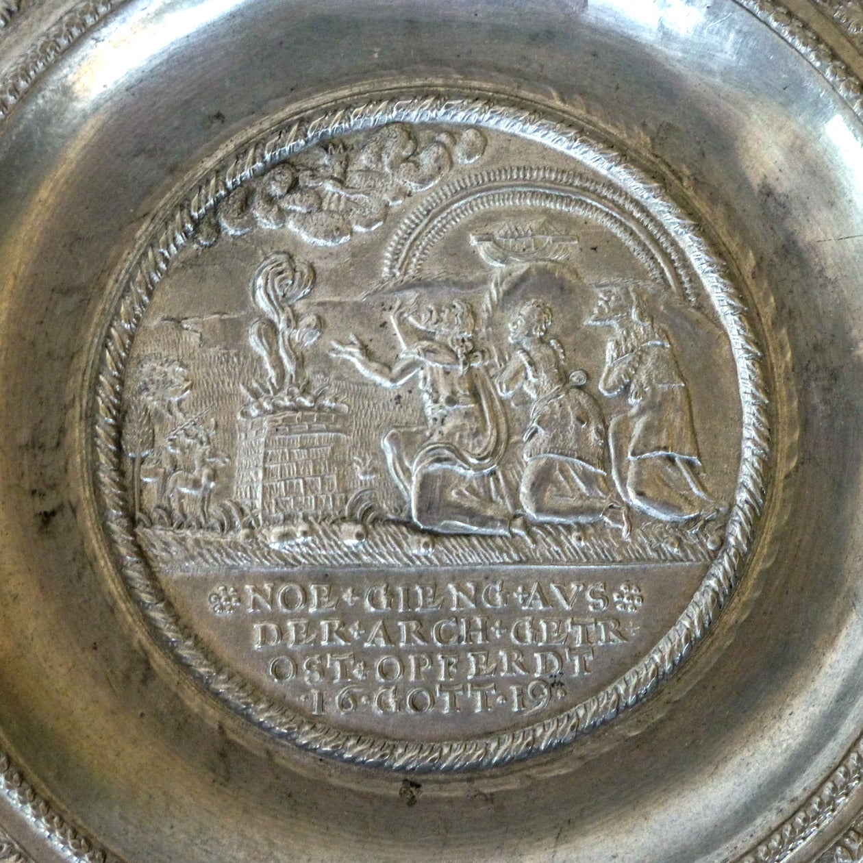 German Pewter Plate, Dated 1619.

A so-called ‘Kurfurstenteller’, the center with the sacrifice of Noah and an inscription below:

NOE.GIENG.AVS.DER.ARCH.GETR

.OST.OPFERDT. 16.GOTT.19

Surrounded by four oval fields incorporating various