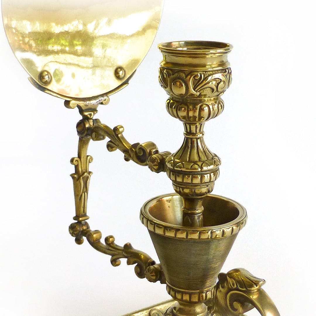 Rare English Brass Victorian Match Holder and Chamberstick with Reflector. Circa 1875. Highly decorated with bearded heads. Reflector rotates to cast light in different directions.

Height 10”

Base 5 5/8” x 5 5/8”