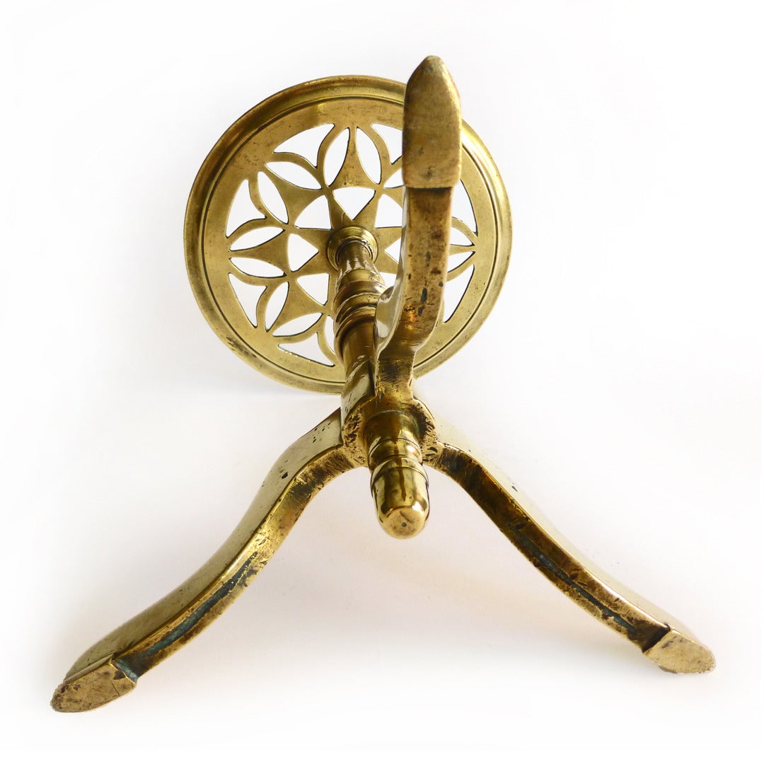 English brass kettle stand or trivet on three legs with hoofed feet. Acorn finial on lower part. Heavy cast brass. Pierced top, circa 1875.

Height 11.5”.

Top diameter 8 5/8”.