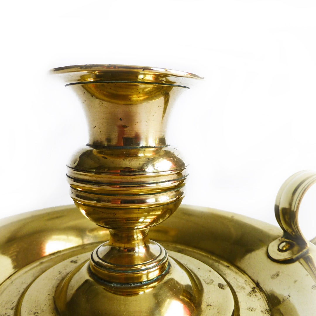 Rare American brass chamberstick, circa 1850. Campana shaped seamed cast socket held with handmade nut. Sheet metal base. Ring handle.

Measures: Length 6”.

Diameter of base 5 3/8”.

Height 3 1/16”.