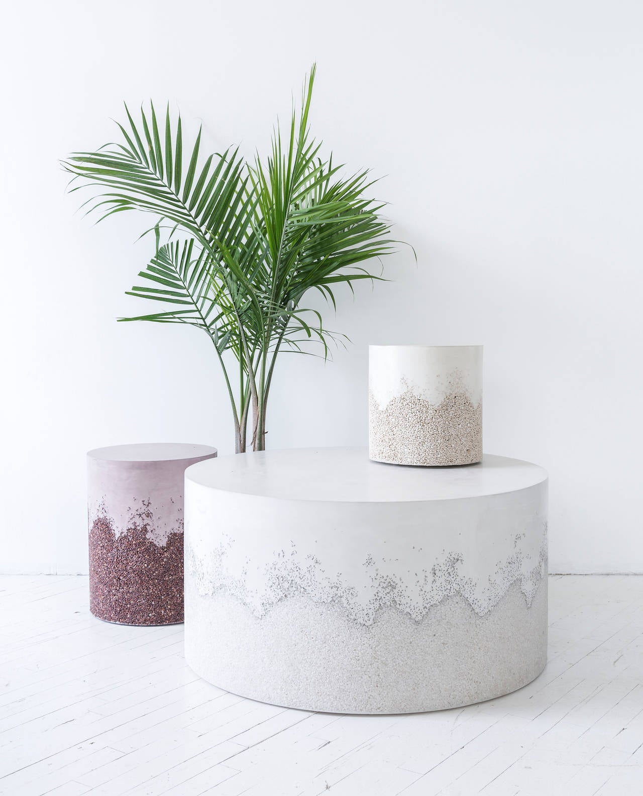 This drum coffee table consists of a hand-dyed white cement top and a packed quartz bottom. The cement is poured by hand over the crushed quartz, creating an organic barrier between the two materials. The piece has a hollow cavity and weighs