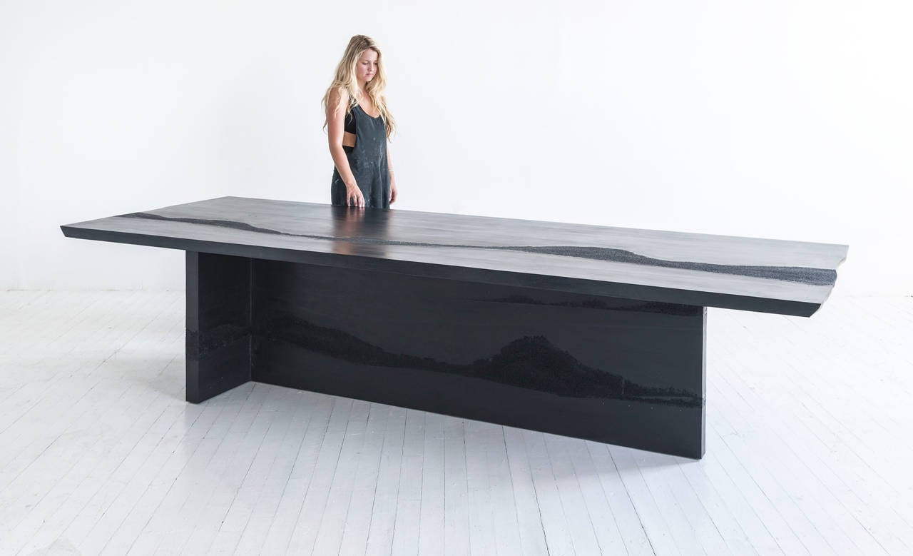 This made-to-order dining table consists of a hand-dyed black cement and black silica. The silica is embedded directly within the cement in an organic nature. 12-14 week lead time. Custom options available, please inquire with the studio.