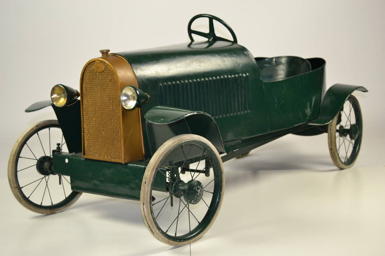 Antique metal pedal car made by Eureka, France, 1920s. Type: Bugatti Sport.
Still in very good solid condition. Has once been repainted, old patina. With logos, brake, Horn, lights, and removable hood.