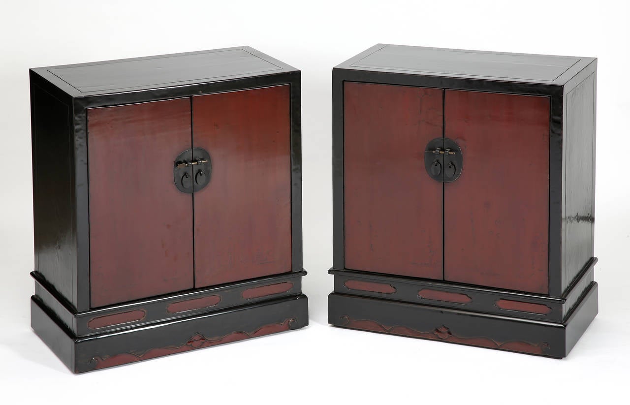 Covered in rich black & red lacquer, of rectangular form with square corners, the fine scholar’s cabinets with a pair of paneled doors, fitted with oval shaped brass lock plate, opening to reveal a drawer in mid-section and bottom panels lifting