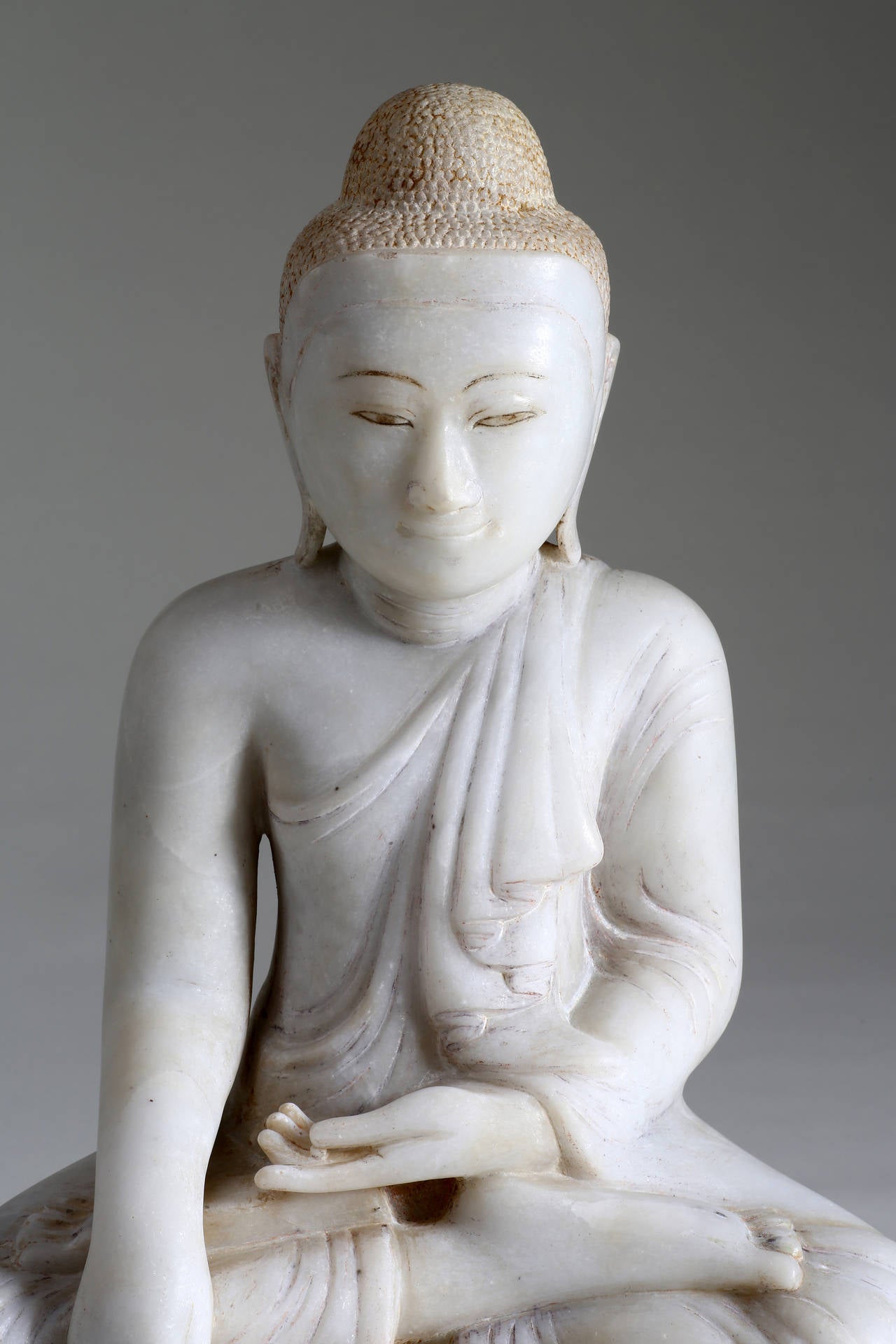 The Buddha is seated on a low base in vajrasana with the right hand in bhumisparsa mudra (the finger-tips touching the earth to symbolize the moment of enlightenment & calling the earth to witness) and the left hand in dhyana mudra (meditation).
