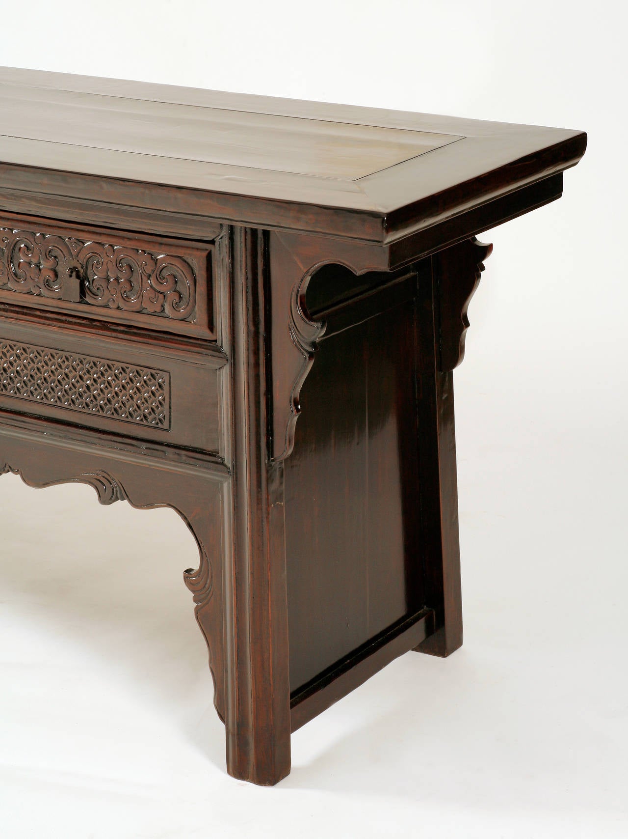 The walnut (hetao mu) raised coffer topped with a floating panel, inset within an ice-plate edged frame, above recessed legs with carved molding, flanked by beaded curvilinear spandrels, a top row of four drawers above a row of three panels with a