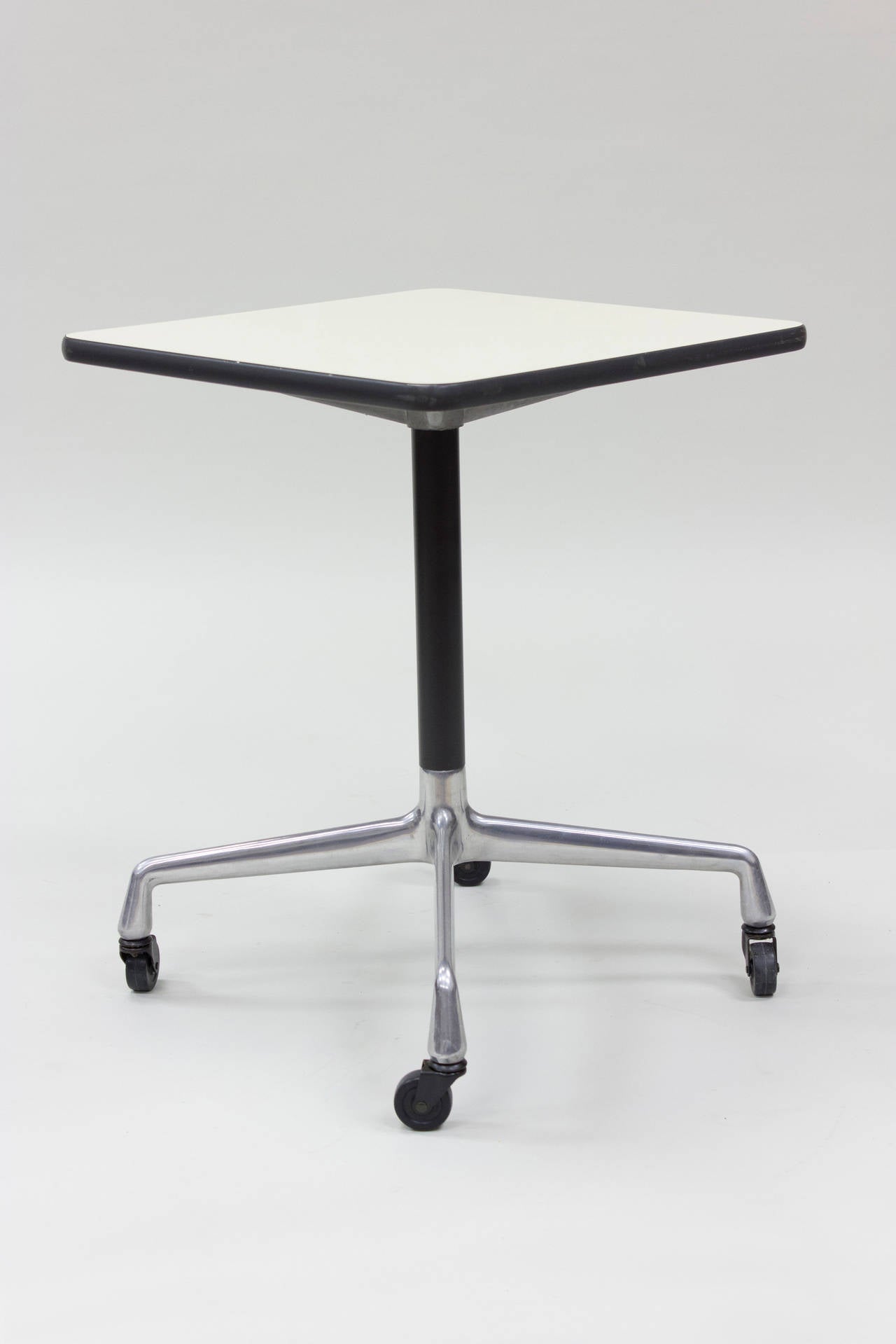 Great Eames Aluminum Group Contract table with castor base. White laminate top is in great condition and has Herman Miller tag to underside. This is the perfect task table for the office or kitchen.