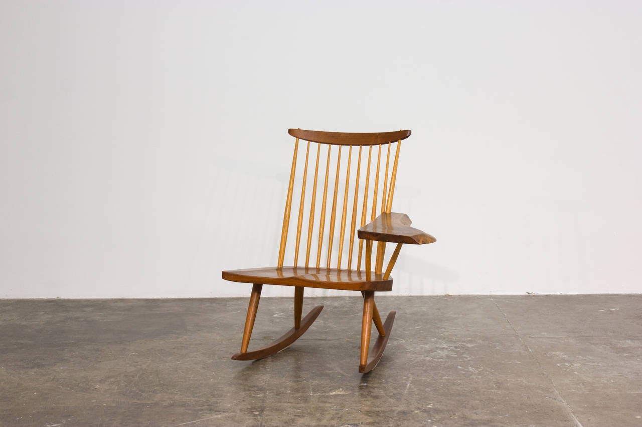 Left-armed Nakashima rocking chair in walnut and hickory with beautiful expressive graining to walnut arm. Made by George Nakashima in his New Hope, PA studio in 1978. Underside signed with original client's name. Copy of original receipt available.