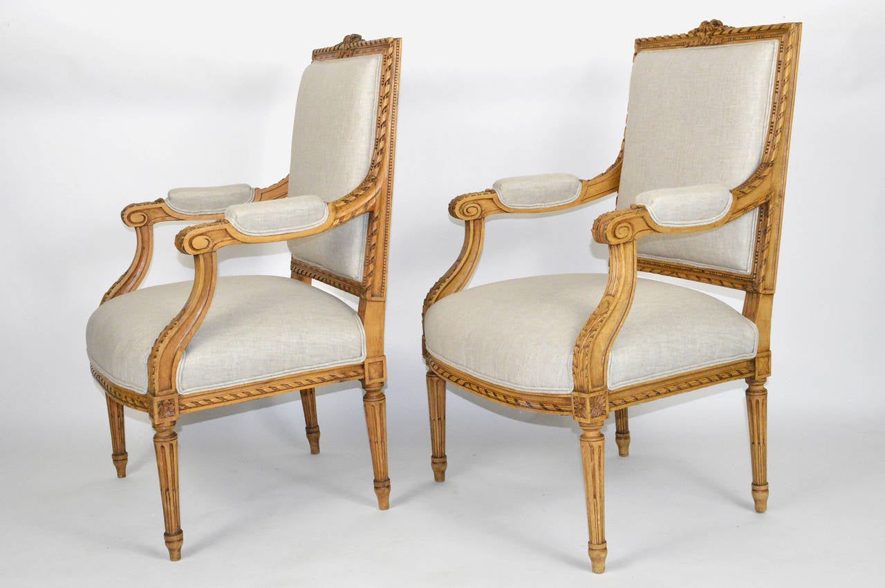 A Pair of Carved Beechwood Louis XVI Style French Armchairs. Covered in Linen.