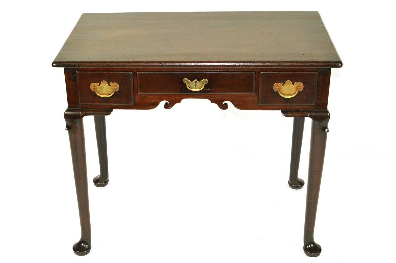 A fine George II mahogany side table. The top with moulded edge, containing three drawers in the frieze with shaped valance, standing on plain cabriole legs with 
