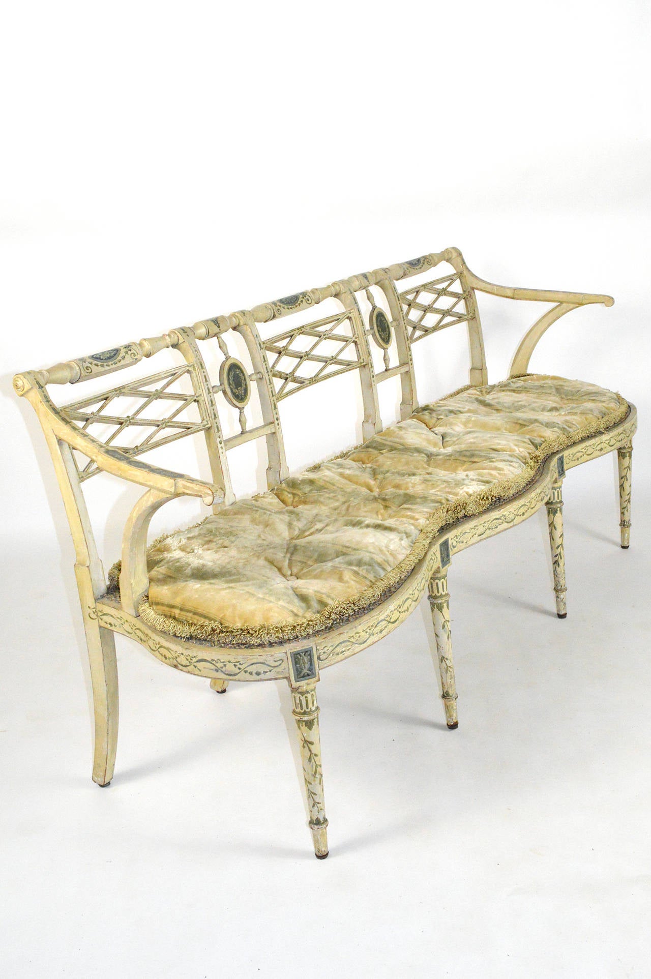 A fine 19th Century Neoclassical Style painted three seat settee. Having a cane seat, turned legs, and a serpentine frame. Fitted with a loose cushion. Painted in Neoclassical taste. Circa 1820.