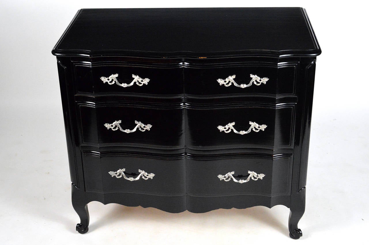 A Gorgeous pair of black laquered, Mid-20th century, three drawer chests. Having a serpentine front, and paneled sides. Raised on Cabriole legs, having nickel plated hardware.