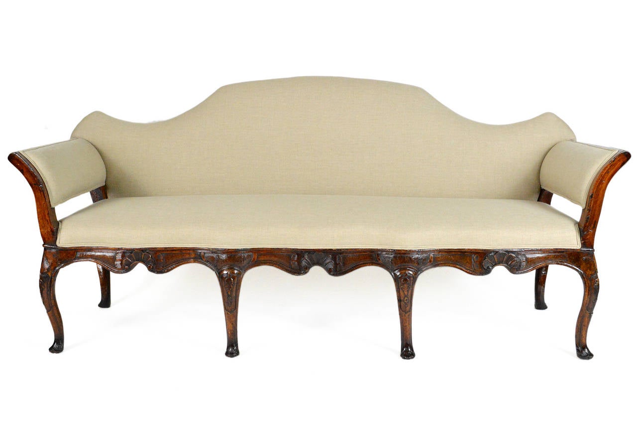 A handsome 18th century Italian venetian carved walnut sofa. Having a padded serpentine back, joined by out-swept arms. The seat above beautifully carved apron. Raised on cabriolet legs with scrolled feet. Warm rich patina is beautiful. Covered in