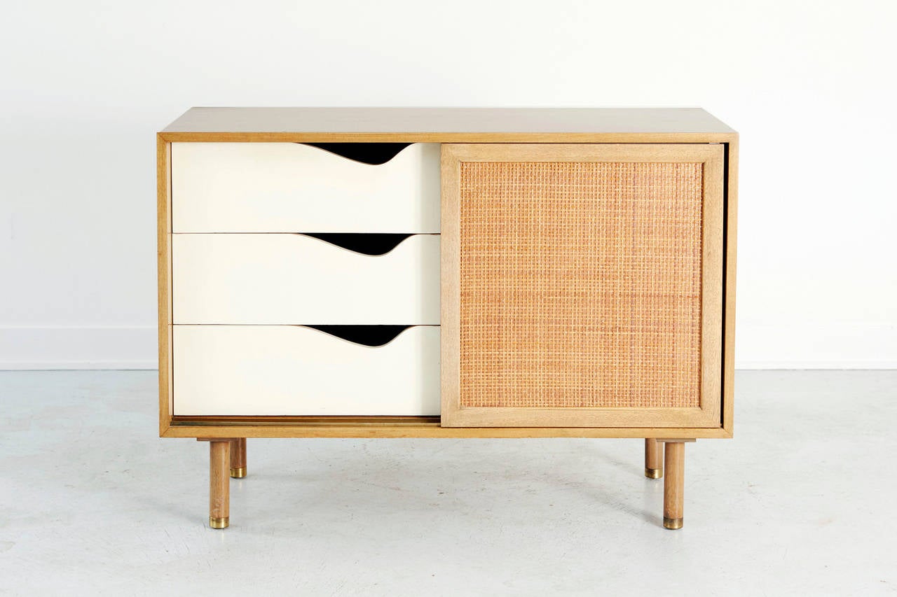 Harvey Probber Walnut and Rattan Credenza with original walnut finish.  Rattan sliding doors and brass leg caps compliment the piece.