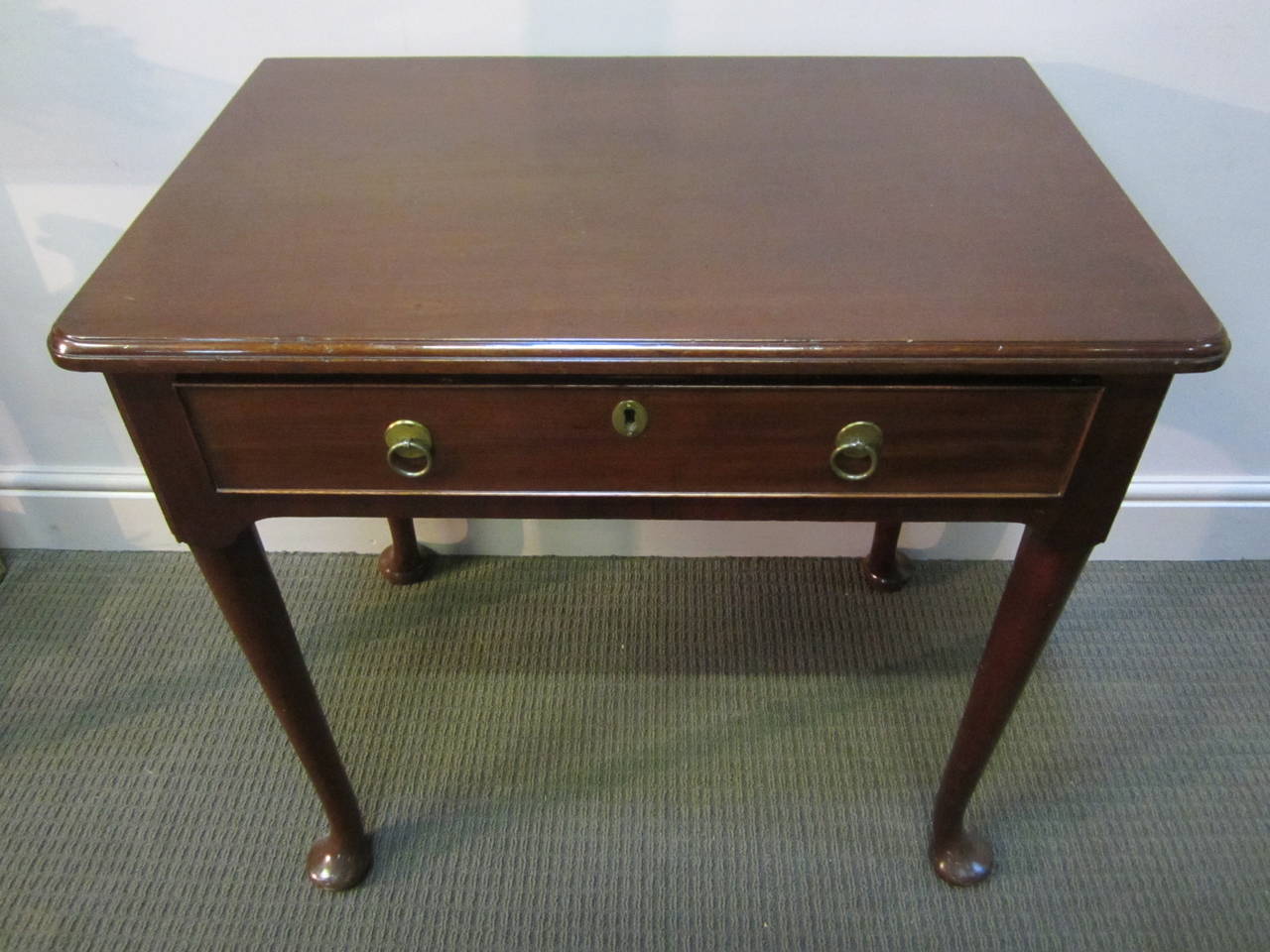 Good George I mahogany side table , the top with a shamfered edge over a single partitioned drawer with central escutcheon and penny ring handles, the housing resting on four tapered legs terminating on pad feet.
 The drawer is stamped Edwards and