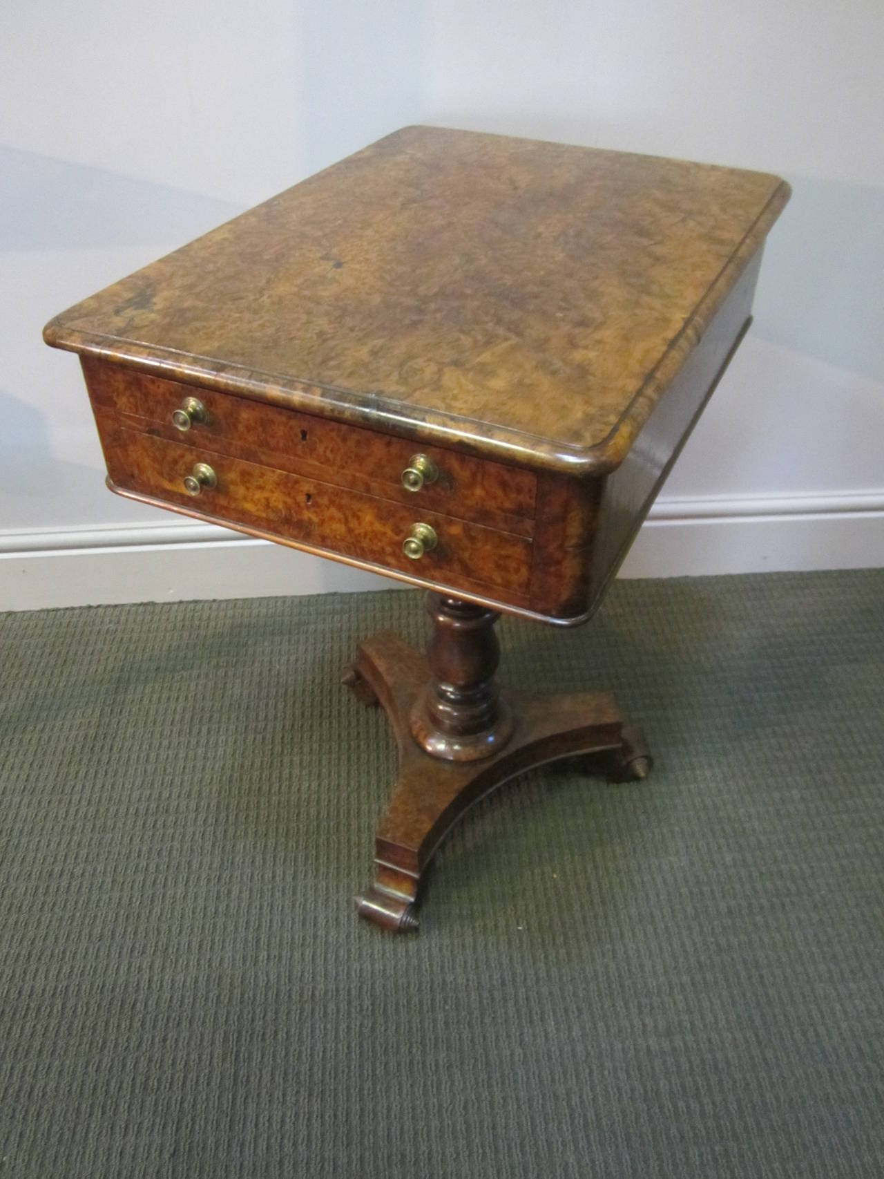 Rare early 19th century burr yew wood pedestal workbox on stand with two drawers at either end, the box on turned central column resting on scrolled feet with casters. Great colour.
