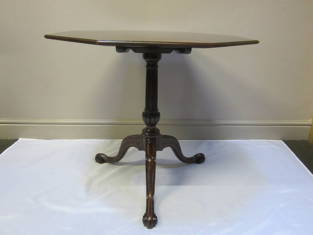 Rare 18th century mahogany octagonal tripod table attributed to Thomas Chippendale, the octagonal radial veneered segmented top, laid over solid mahogany with a lipped edge, set on a square tilting block set between two parallel bearers, the tilting