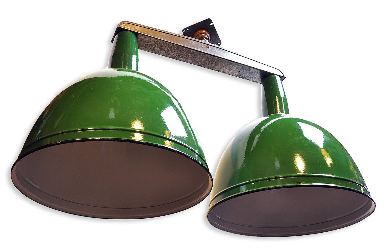 Originally, this fixture was one of several installed in an airplane hangar in rural Iowa. It was built to provide a good amount of light, withstand the elements, and look stylish! Green enamel, in near-perfect condition, covers the exterior of